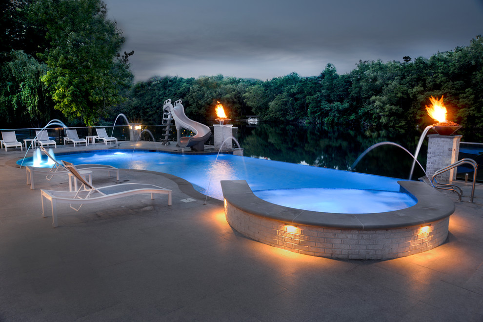 Foto de piscinas y jacuzzis infinitos actuales extra grandes a medida en patio trasero con adoquines de piedra natural