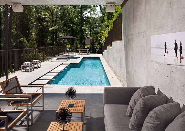 Photo of a medium sized contemporary back rectangular lengths swimming pool in New York with a pool house and concrete paving.