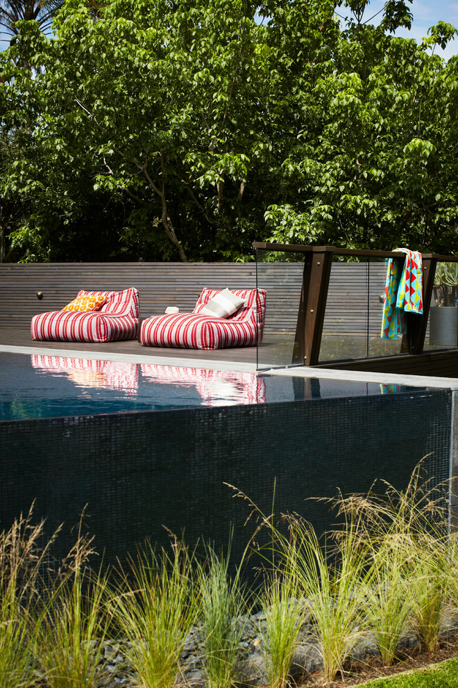 Foto di una grande piscina a sfioro infinito minimal personalizzata dietro casa con pedane