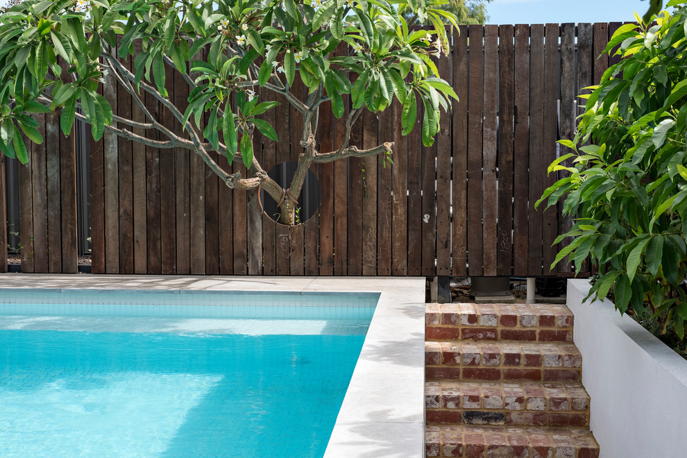 Small classic back rectangular above ground swimming pool in Perth with tiled flooring.