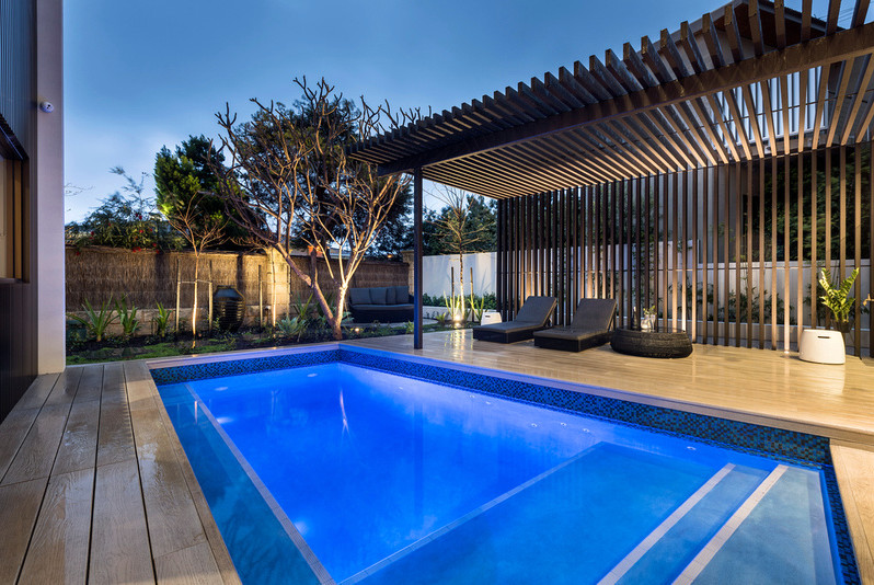 Modelo de piscina contemporánea extra grande en patio trasero con entablado
