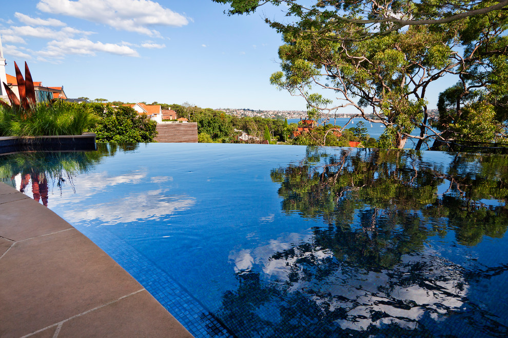 Example of a mid-sized trendy backyard custom-shaped infinity pool design in Sydney
