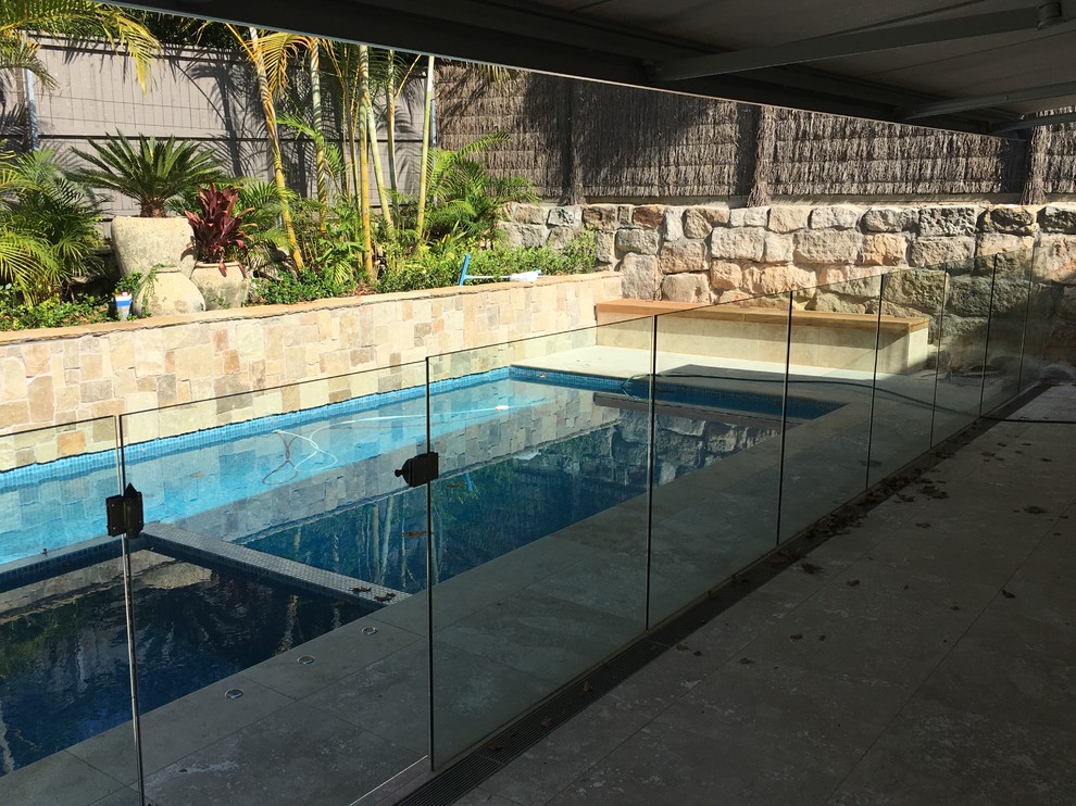 Ejemplo de piscina minimalista en patio trasero con paisajismo de piscina