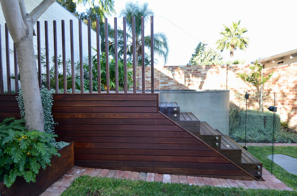 Inspiration pour un petit piscine avec aménagement paysager arrière minimaliste rond avec une terrasse en bois.
