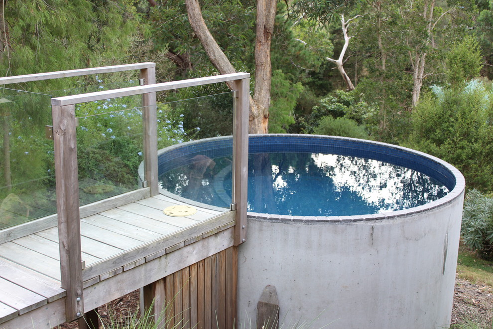 Diseño de piscina elevada contemporánea pequeña redondeada en patio trasero