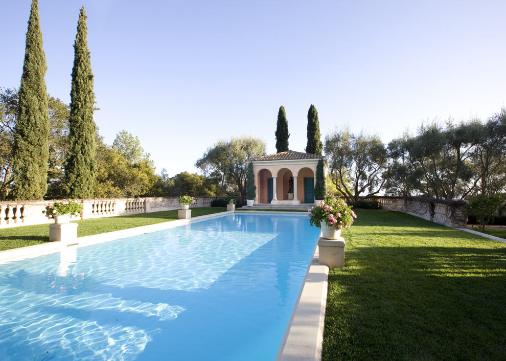 Expansive mediterranean back rectangular lengths swimming pool in Santa Barbara with a pool house.
