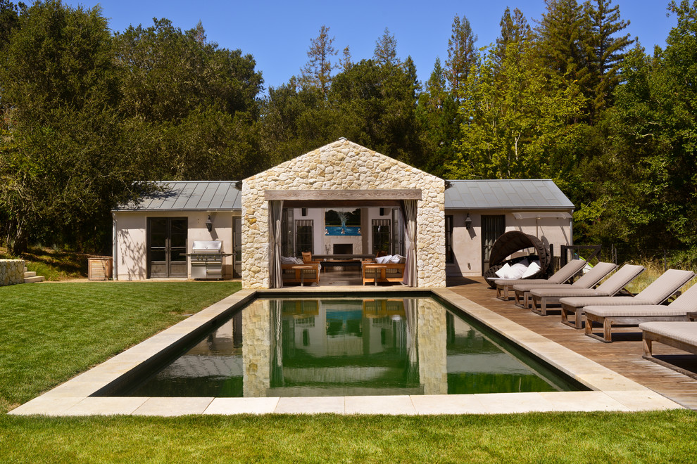 Cette image montre une piscine rustique rectangle avec une terrasse en bois.