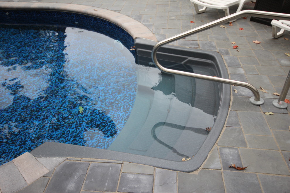 Exemple d'un couloir de nage arrière méditerranéen en forme de haricot de taille moyenne avec un bain bouillonnant et des pavés en pierre naturelle.