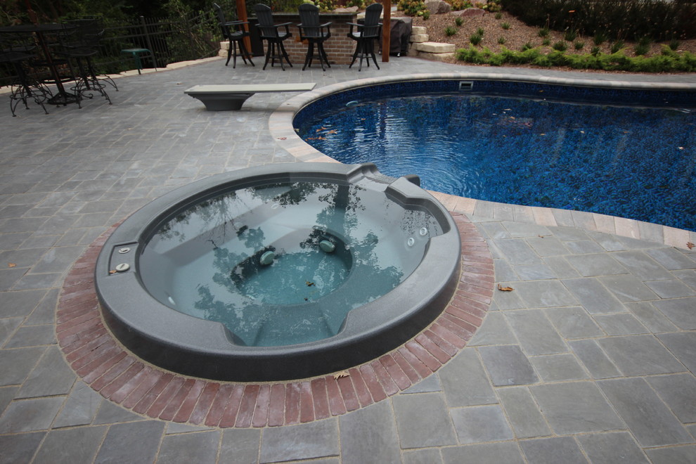 Inspiration for a mid-sized mediterranean backyard stone and kidney-shaped lap hot tub remodel in Chicago