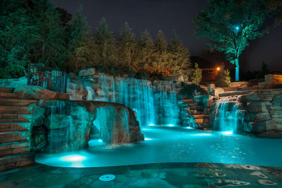 Example of a huge mountain style backyard stone and custom-shaped natural pool fountain design in Oklahoma City