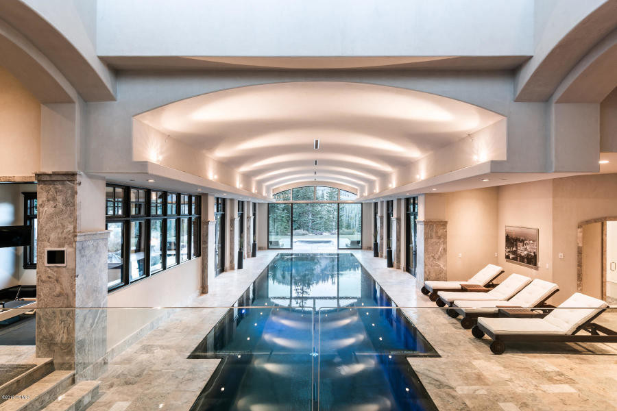 Immagine di un'ampia piscina coperta classica rettangolare con una dépendance a bordo piscina e pavimentazioni in pietra naturale