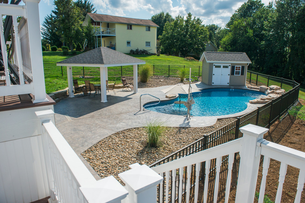Foto di una piscina naturale stile shabby personalizzata di medie dimensioni e dietro casa con fontane e cemento stampato