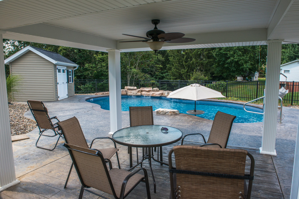 Immagine di una piscina naturale stile shabby personalizzata di medie dimensioni e dietro casa con fontane e cemento stampato