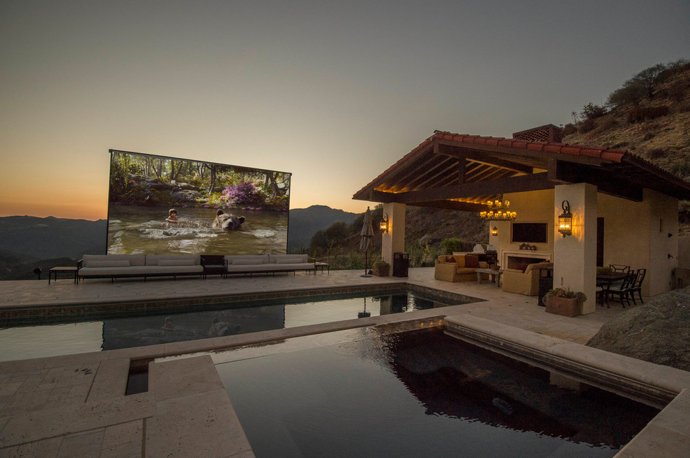 Ejemplo de casa de la piscina y piscina alargada clásica renovada grande rectangular en patio trasero con adoquines de piedra natural