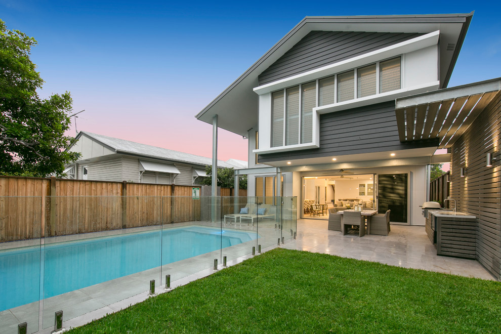 Design ideas for a large contemporary back custom shaped swimming pool in Brisbane with tiled flooring.
