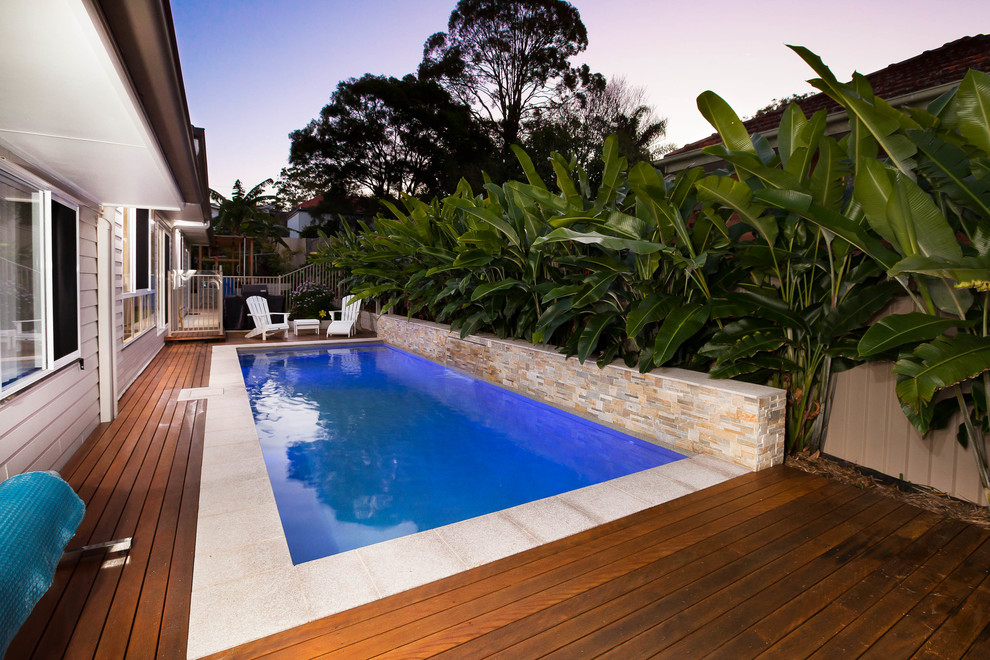 Ejemplo de piscina alargada moderna de tamaño medio rectangular en patio lateral con entablado