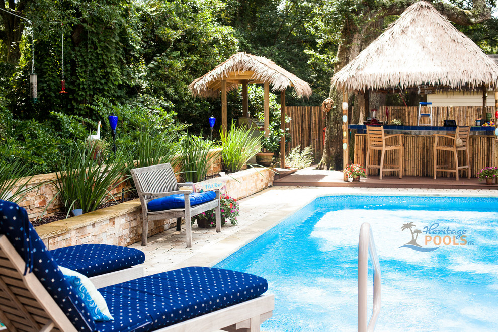 Foto di una piscina tropicale dietro casa con pavimentazioni in pietra naturale