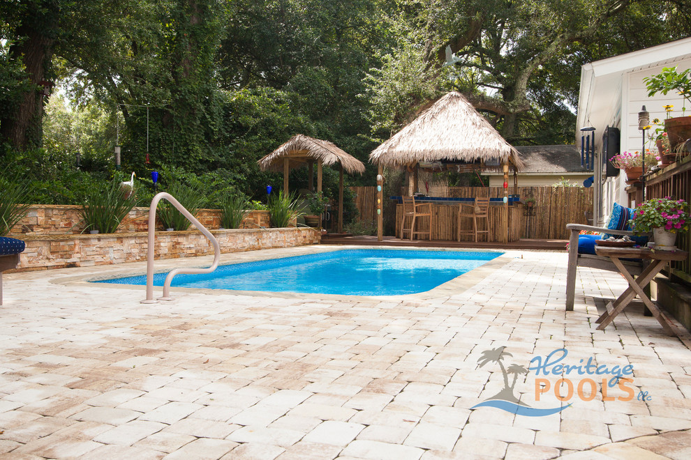 Foto de piscina exótica en patio trasero con adoquines de piedra natural