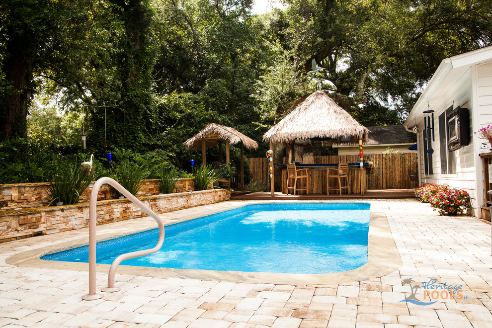 Esempio di una piscina tropicale dietro casa con pavimentazioni in pietra naturale