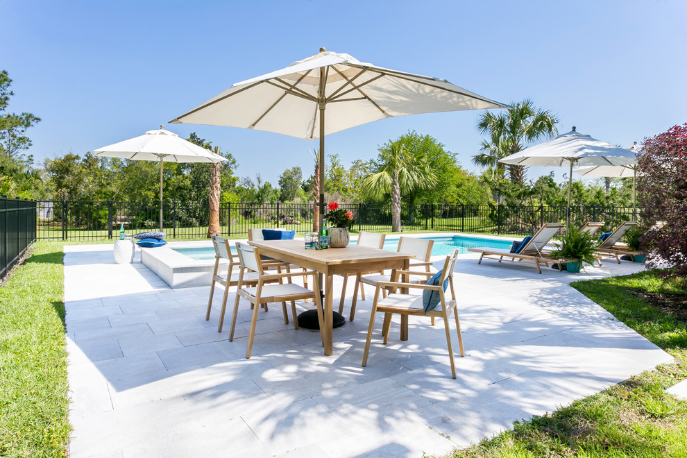 Large beach style backyard concrete paver and rectangular pool photo in Charleston