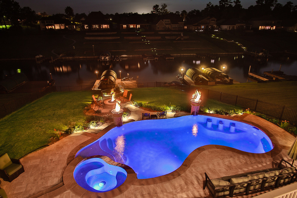 Esempio di un'ampia piscina a sfioro infinito eclettica personalizzata dietro casa con fontane e piastrelle