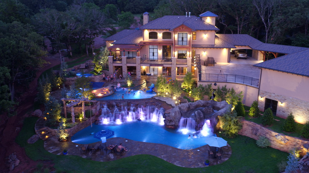 Ispirazione per un'ampia piscina naturale classica personalizzata dietro casa con fontane e pavimentazioni in pietra naturale
