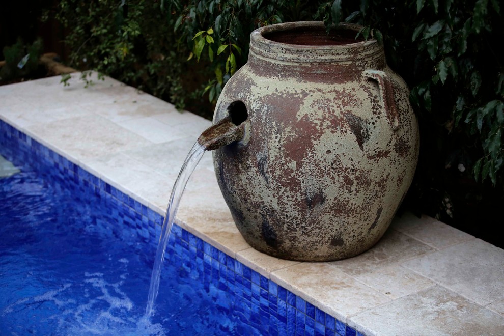 Foto di una piscina monocorsia minimal personalizzata di medie dimensioni e dietro casa con pavimentazioni in pietra naturale e una vasca idromassaggio