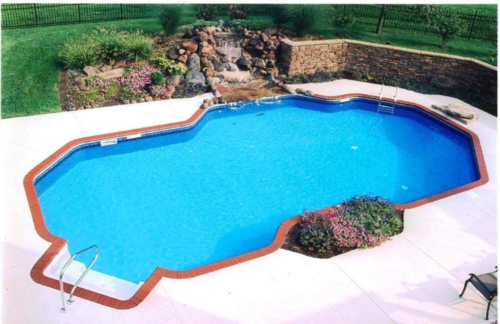 Ejemplo de piscina con fuente alargada clásica renovada de tamaño medio a medida en patio trasero con adoquines de hormigón