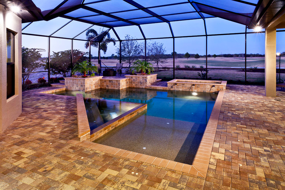 Foto di una piscina a sfioro infinito chic personalizzata di medie dimensioni e dietro casa con una vasca idromassaggio e pavimentazioni in cemento