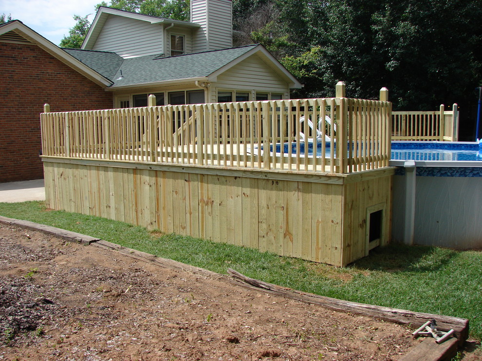 Exemple d'une piscine hors-sol et arrière tendance de taille moyenne et ronde avec une terrasse en bois.