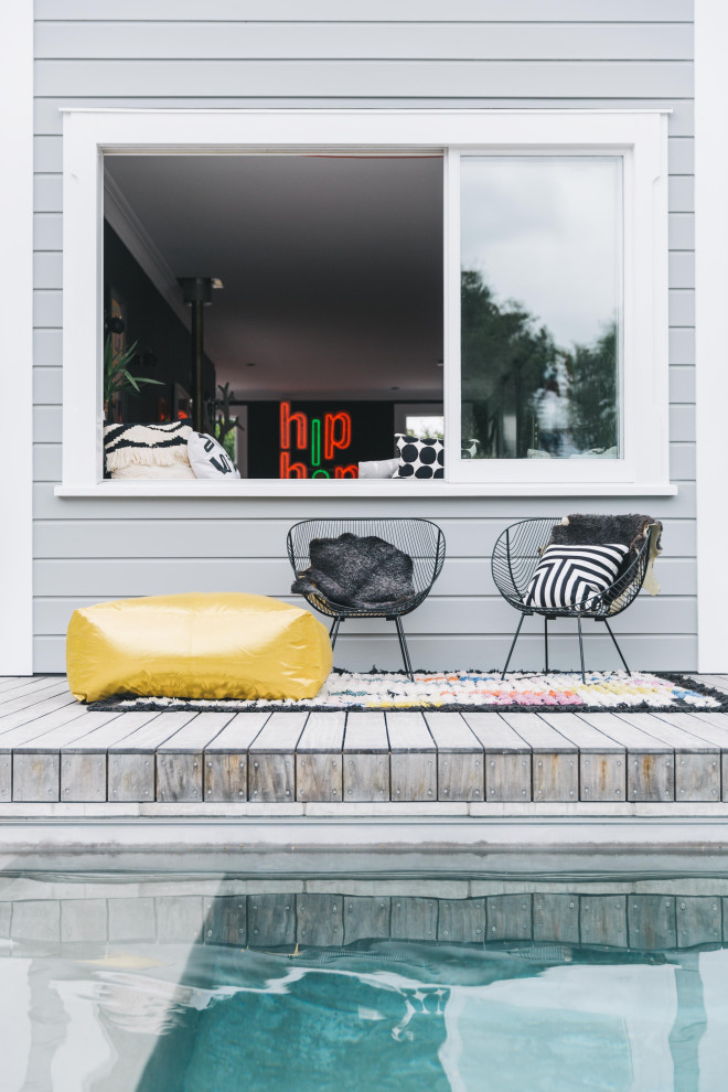 Idées déco pour une piscine arrière contemporaine rectangle avec une terrasse en bois.