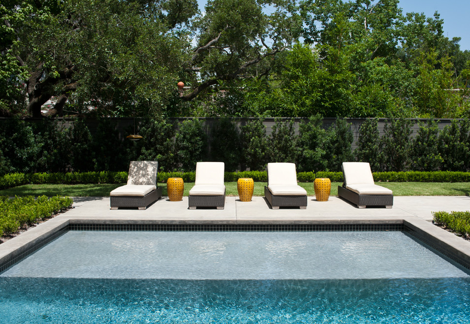 Diseño de piscina contemporánea de tamaño medio rectangular en patio trasero con losas de hormigón