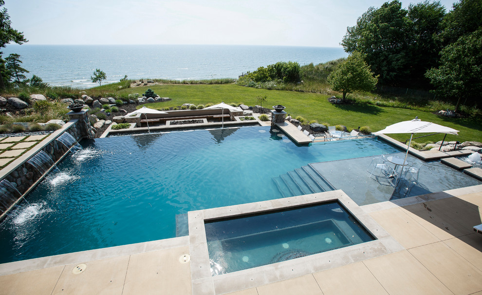 Geräumiger Moderner Infinity-Pool hinter dem Haus in individueller Form mit Wasserspiel und Natursteinplatten in Grand Rapids