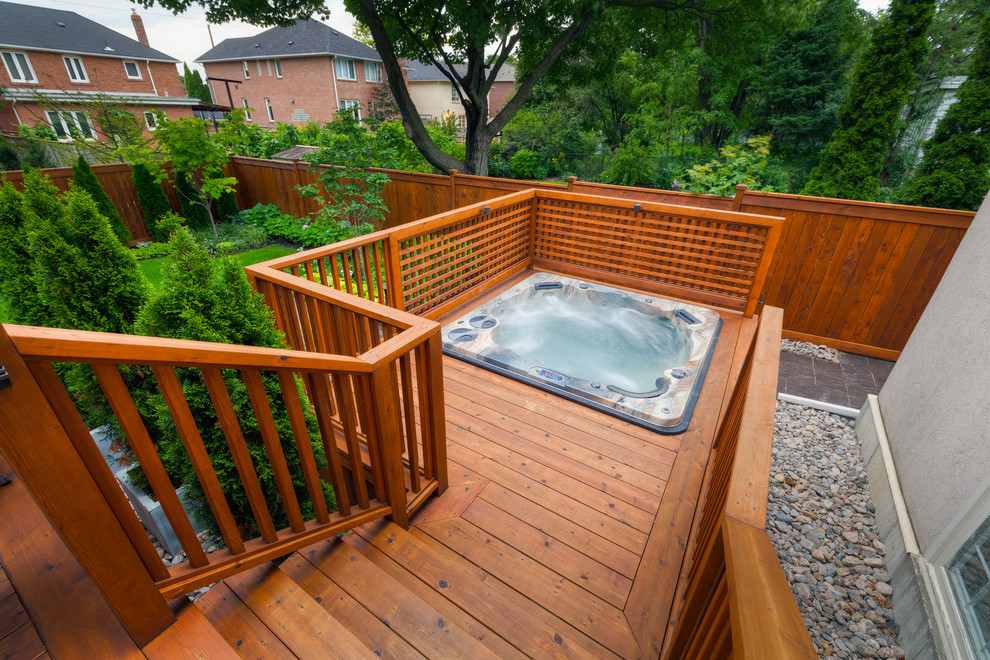 Réalisation d'une piscine arrière minimaliste avec un bain bouillonnant et une terrasse en bois.