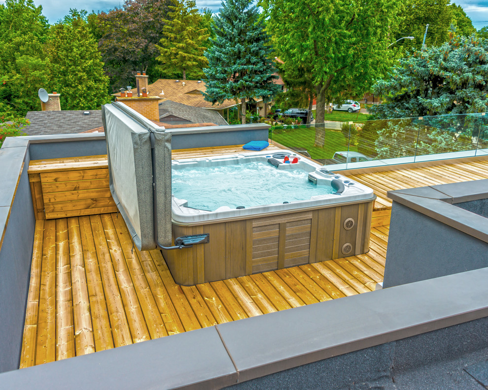 Cette image montre une piscine sur toit minimaliste de taille moyenne avec un bain bouillonnant et une terrasse en bois.