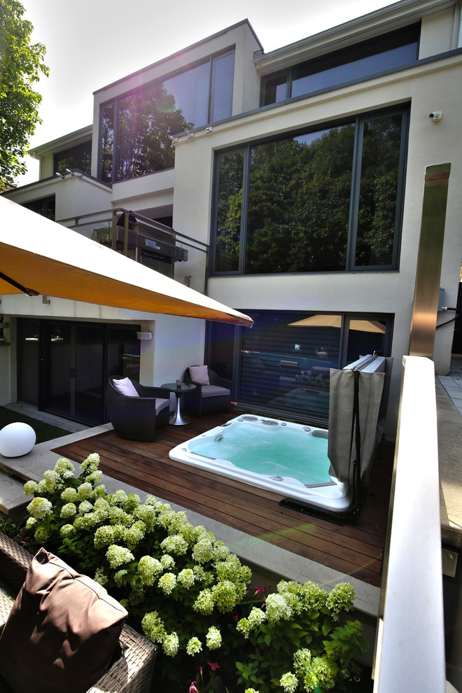 Esempio di una piscina minimalista dietro casa con una vasca idromassaggio e pedane