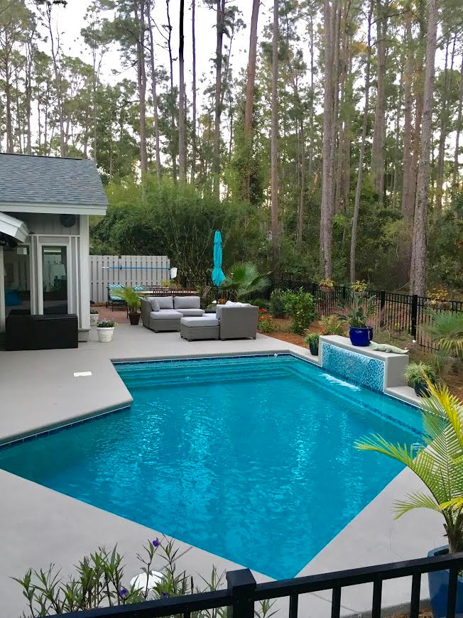 Modelo de piscina con fuente alargada clásica renovada de tamaño medio en forma de L en patio trasero con granito descompuesto