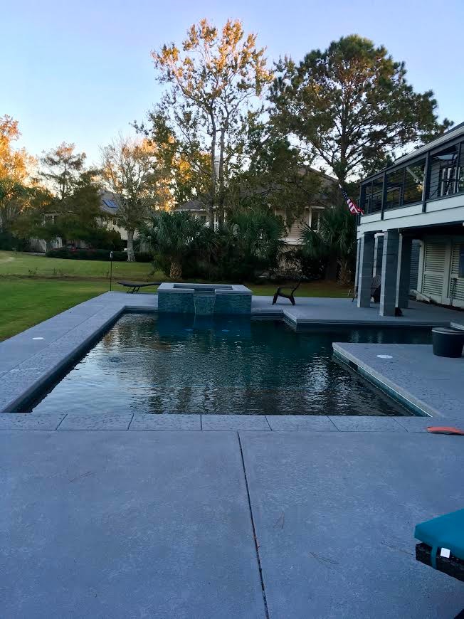 Modelo de piscinas y jacuzzis alargados tradicionales renovados pequeños en forma de L en patio trasero con adoquines de hormigón