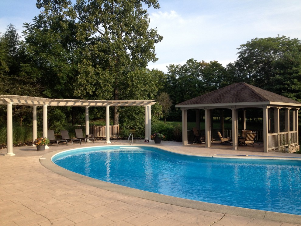 Example of a large transitional backyard concrete paver and custom-shaped pool design in Columbus