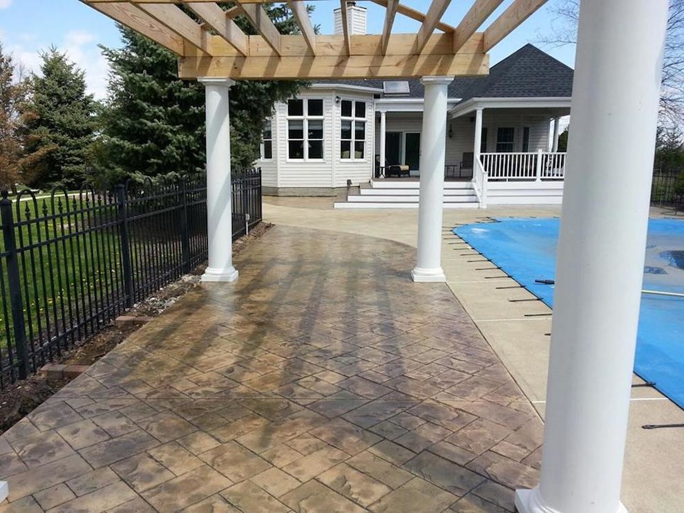 Diseño de piscina clásica de tamaño medio redondeada en patio con suelo de baldosas