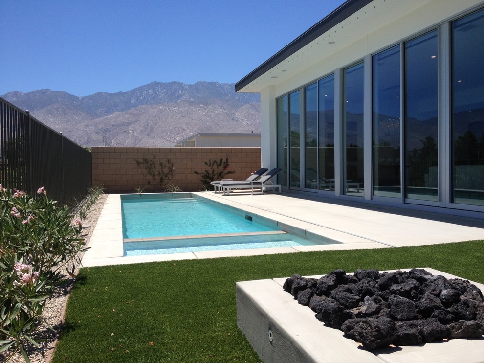 Foto de piscinas y jacuzzis alargados actuales grandes rectangulares en patio trasero con adoquines de hormigón