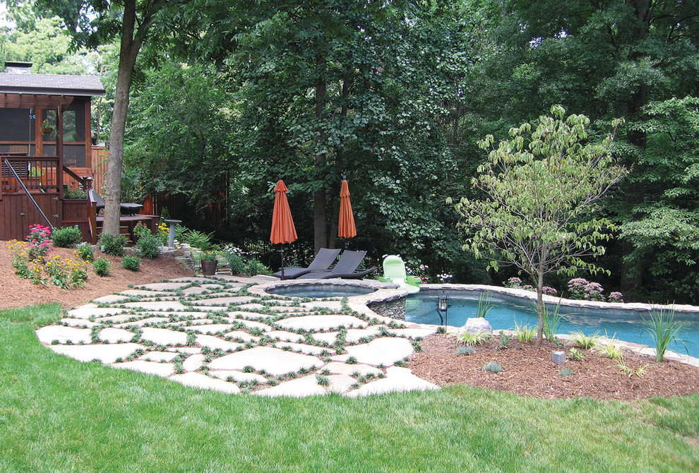 Idee per una grande piscina chic personalizzata dietro casa con una vasca idromassaggio e pavimentazioni in pietra naturale
