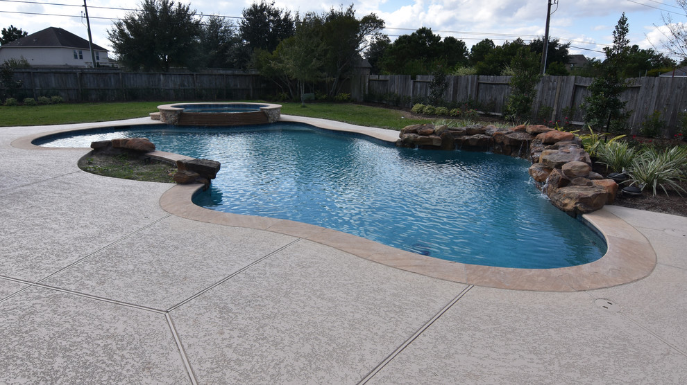 Design ideas for a large world-inspired custom shaped natural swimming pool in Houston with decking.