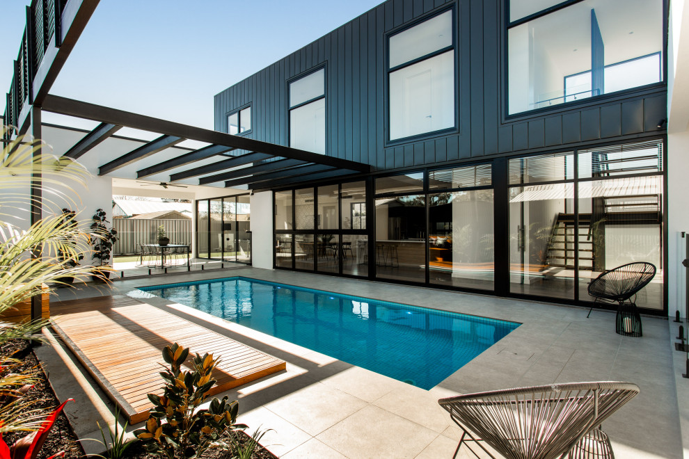 Modelo de piscina contemporánea rectangular en patio lateral