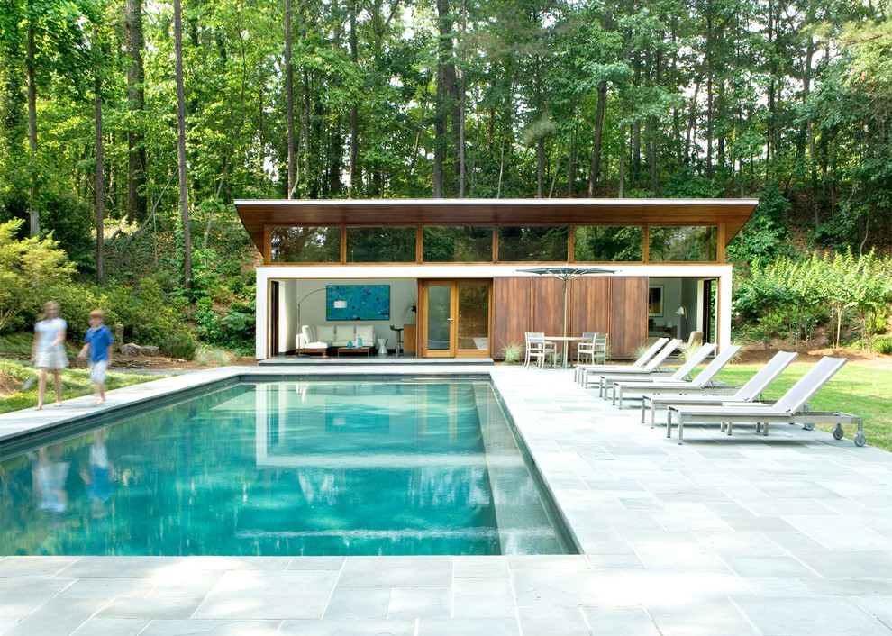 Свежая идея для дизайна: большой прямоугольный, естественный бассейн на заднем дворе в стиле модернизм с домиком у бассейна и покрытием из каменной брусчатки - отличное фото интерьера