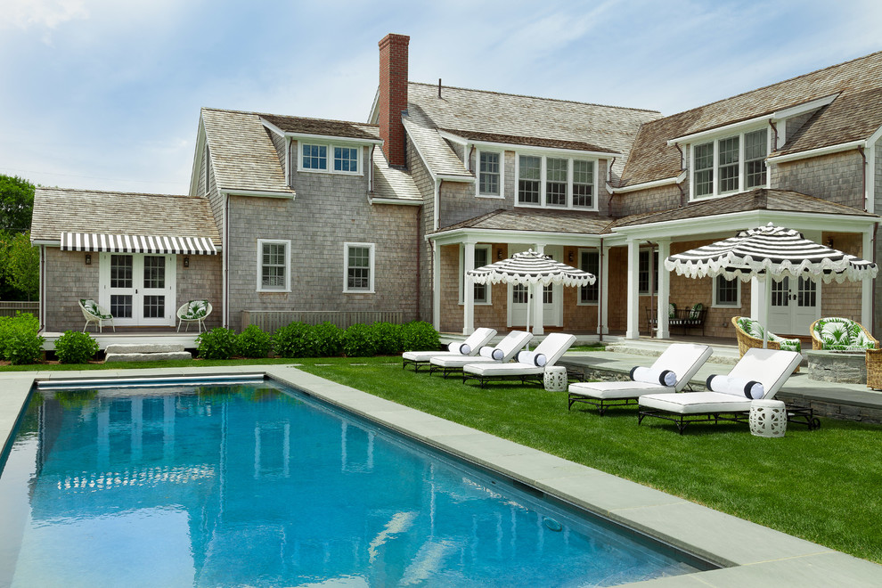 Ejemplo de casa de la piscina y piscina natural costera de tamaño medio rectangular en patio trasero con adoquines de piedra natural