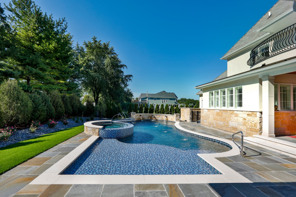 Aménagement d'un piscine avec aménagement paysager arrière moderne de taille moyenne et sur mesure avec des pavés en pierre naturelle.