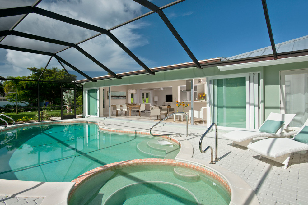 Modelo de piscinas y jacuzzis naturales contemporáneos de tamaño medio a medida en patio trasero con adoquines de ladrillo