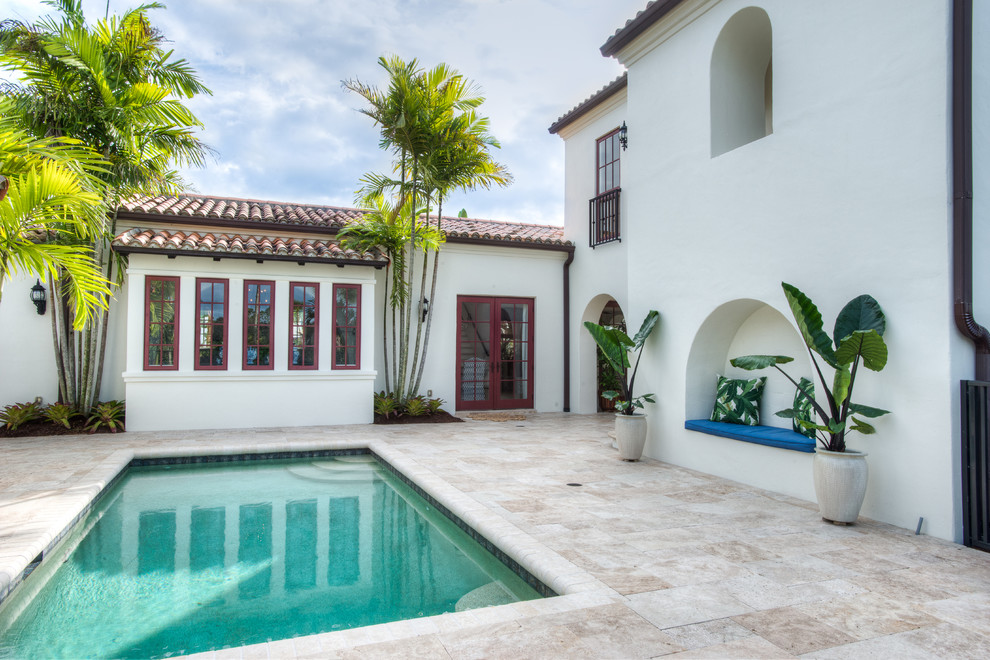 マイアミにある地中海スタイルのおしゃれな中庭プール (天然石敷き) の写真