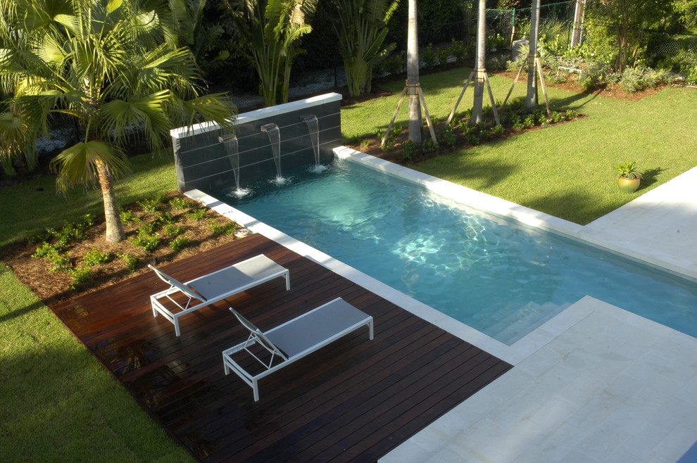 Imagen de piscina con fuente alargada moderna extra grande en forma de L en patio con adoquines de hormigón